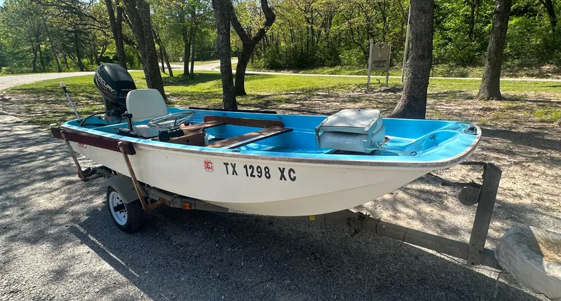 Slide: The Image of 1967 Boston Whaler 13 boat on trailer, parked in a wooded area. - 1