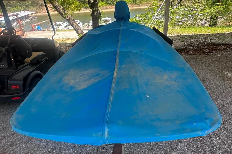 Slide: The Image of 1967 Boston Whaler 13 boat covered in blue tarp, parked outdoors. - 13