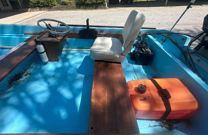 Slide: The Image of 1967 Boston Whaler 13 interior with wooden seats, steering wheel, and orange fuel tank. - 5