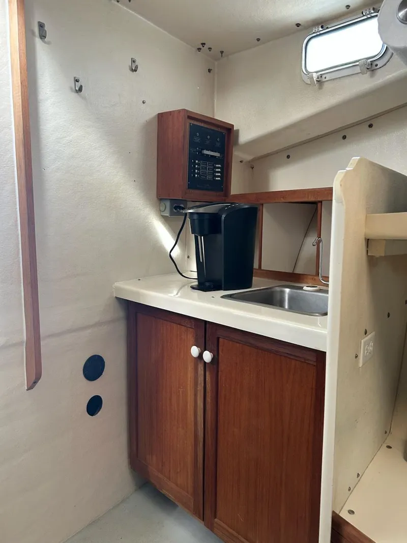 Slide: The Image of 1999 Provincial 42 Fishing Boat interior with kitchenette, sink, and wooden cabinets. - 22