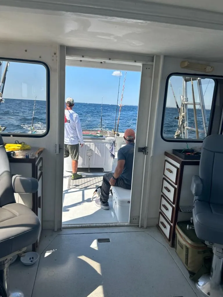 Slide: The Image of Interior view of a 1999 Provincial 42 Fishing Boat with two people fishing at sea. - 24