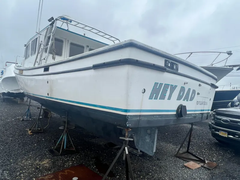 Slide: The Image of 1999 Provincial 42 Fishing Boat on stands, named "Hey Dad," in a boatyard. - 3