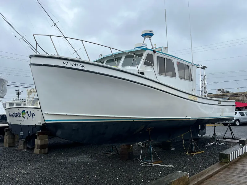 Slide: The Image of 1999 Provincial 42 Fishing Boat on dry dock, white hull, overcast sky. - 4