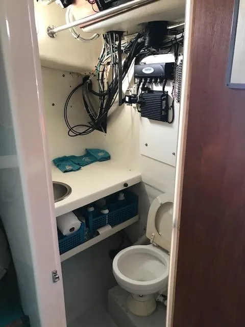 Slide: The Image of 1999 Provincial 42 Fishing Boat bathroom with toilet, sink, and storage shelves. - 7