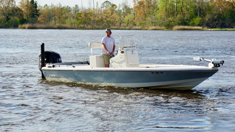 Slide: The Image of Man operating 2011 Pathfinder 2300 HPS boat on a calm river. - 2