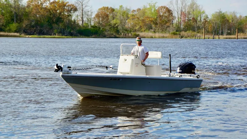 Slide: The Image of 2011 Pathfinder 2300 HPS boat cruising on a calm river with trees in the background. - 6