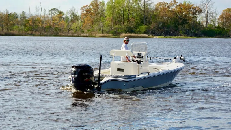 Slide: The Image of 2011 Pathfinder 2300 HPS boat cruising on a calm river with trees in the background. - 7