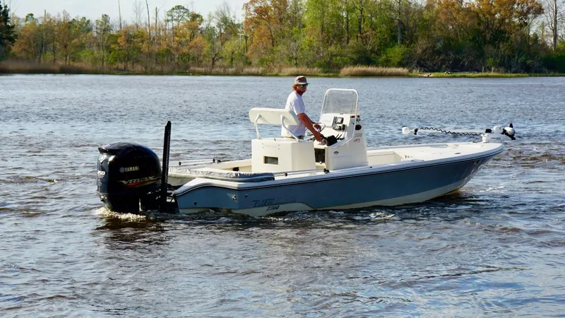 Slide: The Image of 2011 Pathfinder 2300 HPS boat on a calm river with a person steering. - 8