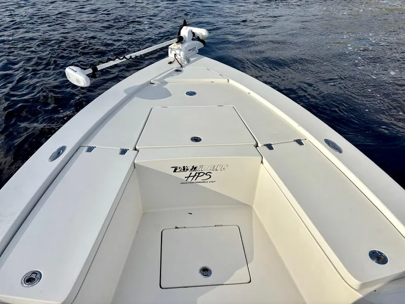 Slide: The Image of 2011 Pathfinder 2300 HPS boat deck with storage compartments and trolling motor on water. - 9