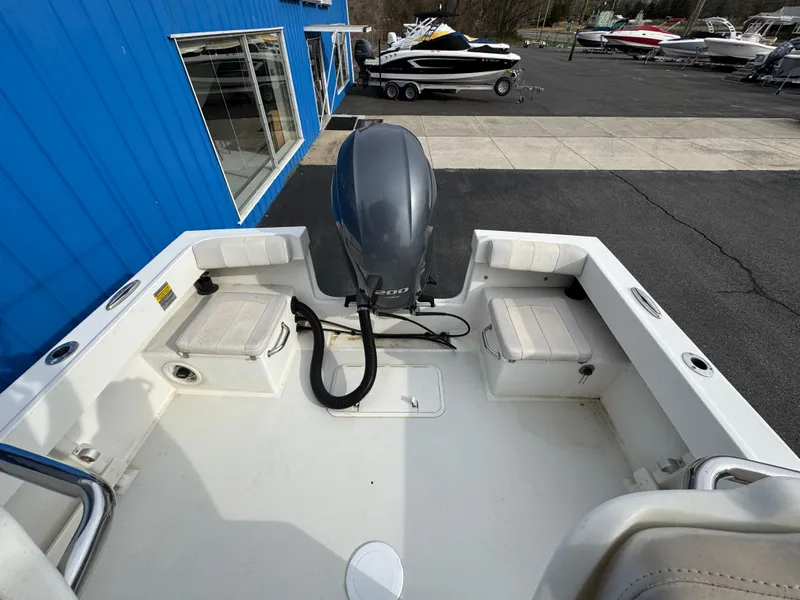 Slide: The Image of 2016 Parker 2300 Special Edition boat with outboard motor, docked near blue building. - 25