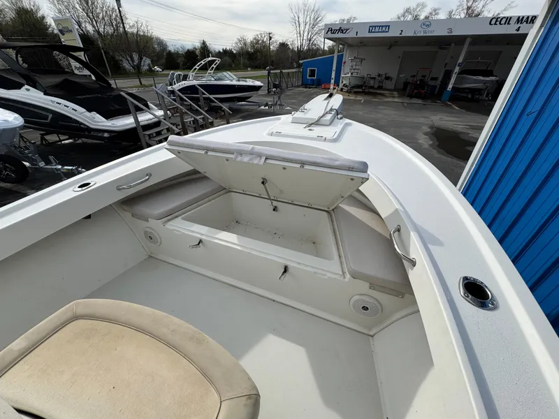 Slide: The Image of 2016 Parker 2300 Special Edition boat with open storage compartment at a marina. - 27