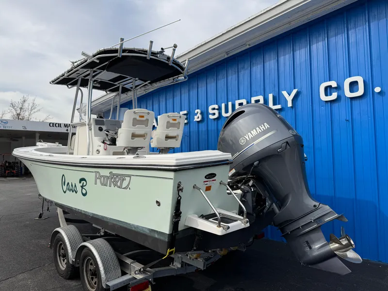 Slide: The Image of 2016 Parker 2300 Special Edition boat with Yamaha motor on trailer, parked outside a blue building. - 3