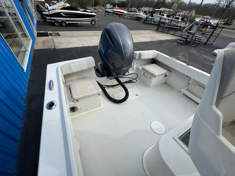 Slide: The Image of 2016 Parker 2300 Special Edition boat with outboard motor, docked near blue building. - 5