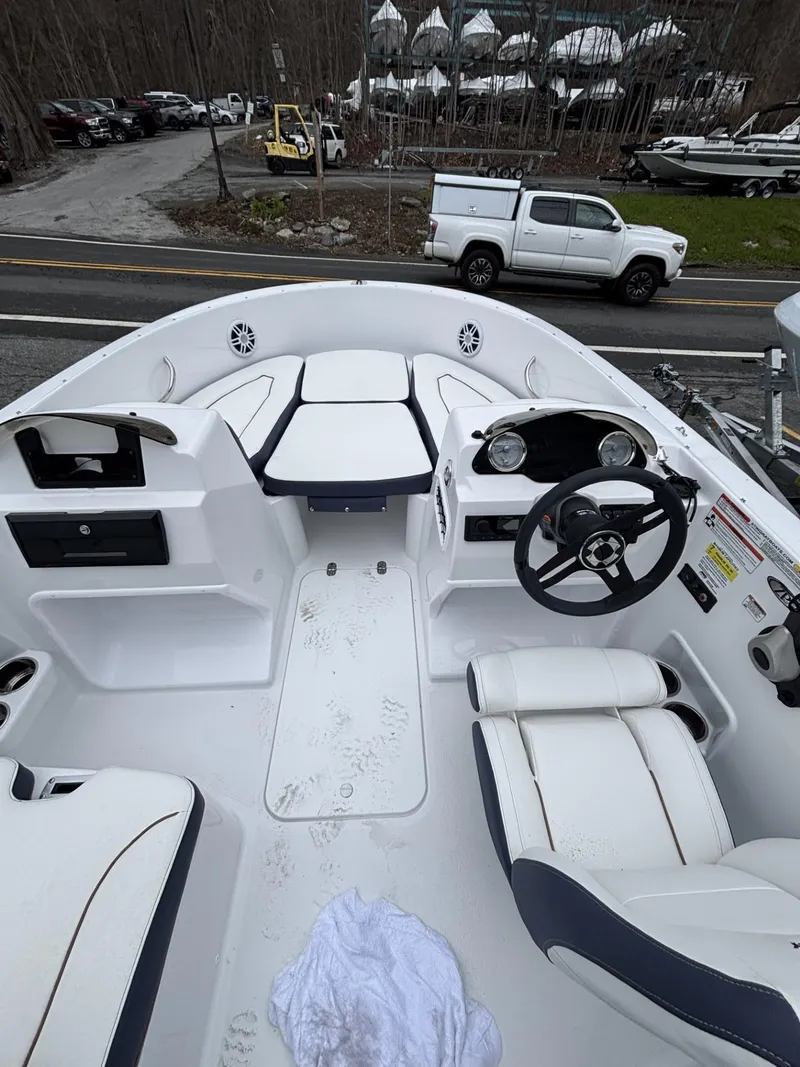 Slide: The Image of 2025 Stingray 172 SC boat interior with white seating and steering wheel. - 18