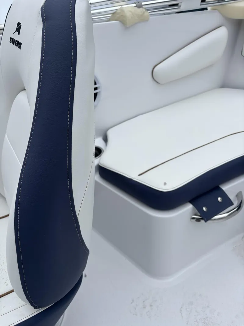 Slide: The Image of 2025 Stingray 172 SC boat interior with white and navy seating. - 2