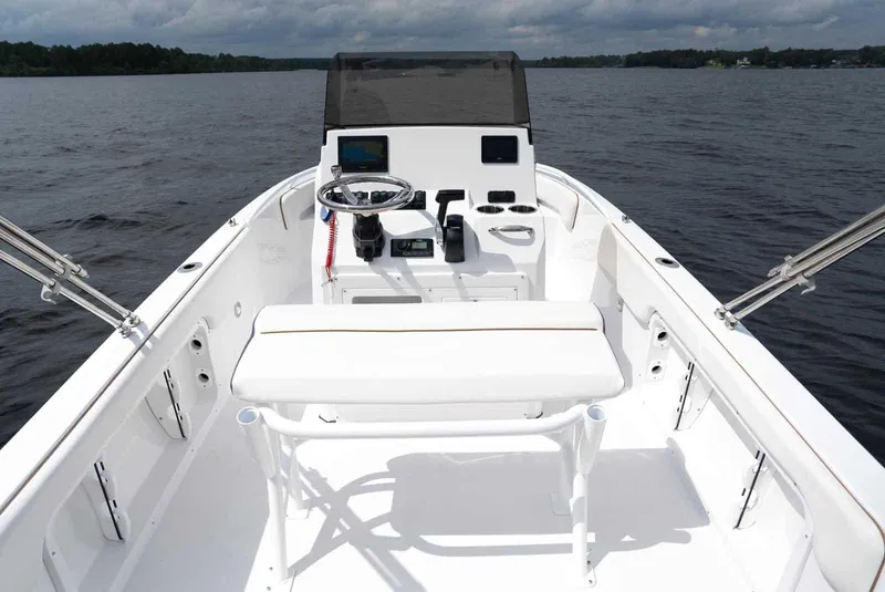 Slide: The Image of 2025 Stingray 173 CC boat interior with steering console on a calm lake. - 15
