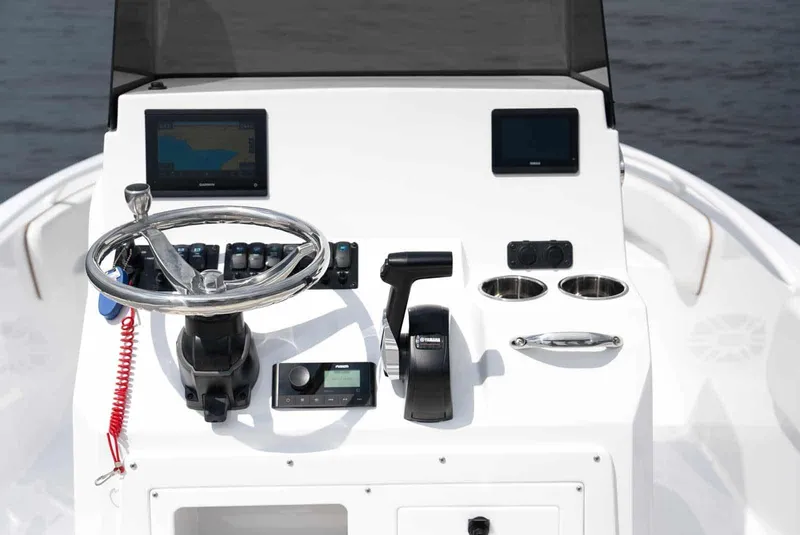 Slide: The Image of 2025 Stingray 173 CC boat dashboard with steering wheel, controls, and navigation screens. - 16