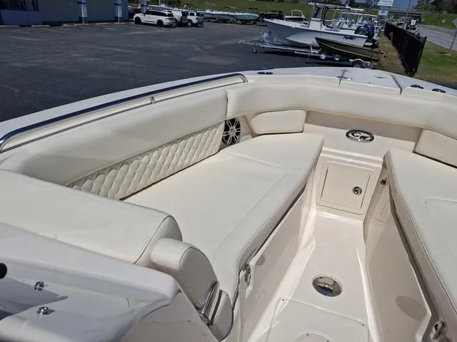 Slide: The Image of 2025 Grady-White Freedom 307 boat interior with white cushioned seating and storage compartments. - 14