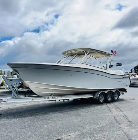 Slide: The Image of 2025 Grady-White Freedom 307 boat on trailer under cloudy sky. - 2