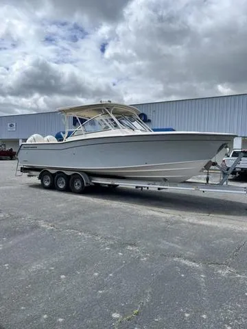 Slide: The Image of 2025 Grady-White Freedom 307 boat on trailer, parked outdoors under cloudy sky. - 3