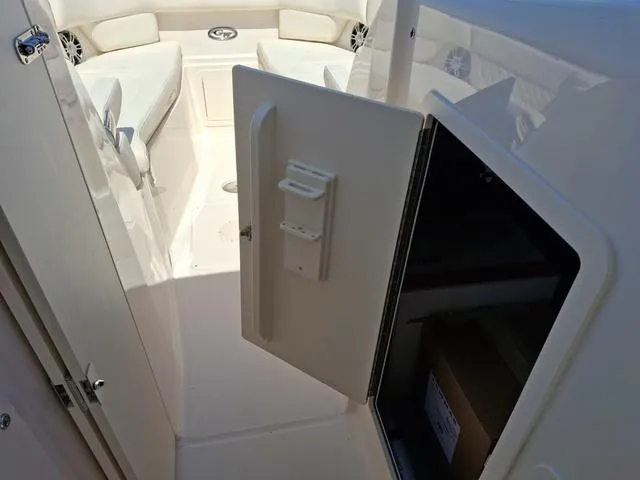 Slide: The Image of 2025 Grady-White Freedom 307 boat interior with open storage compartment and seating area. - 33