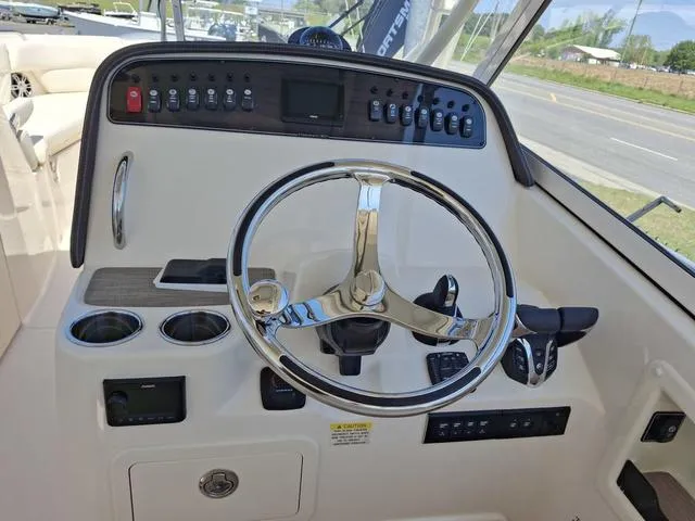 Slide: The Image of 2025 Grady-White Freedom 307 boat dashboard with steering wheel and controls. - 35