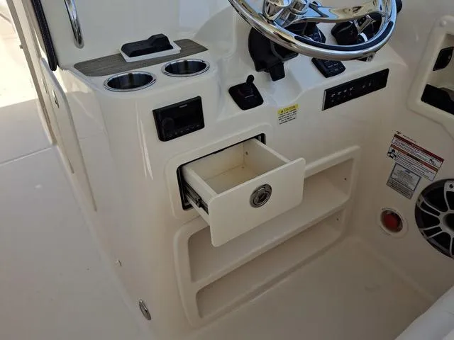 Slide: The Image of 2025 Grady-White Freedom 307 boat console with open storage drawer and steering wheel. - 39