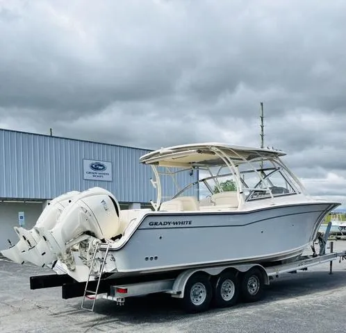 Slide: The Image of 2025 Grady-White Freedom 307 boat on trailer, parked outdoors under cloudy sky. - 4