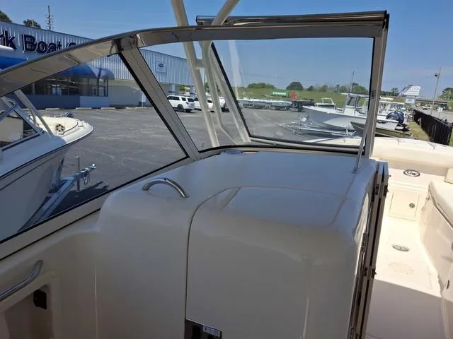 Slide: The Image of 2025 Grady-White Freedom 307 boat interior with windshield and docked boats in background. - 43
