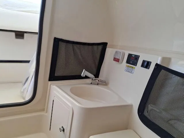 Slide: The Image of 2025 Grady-White Freedom 307 boat interior with sink and storage compartments. - 48