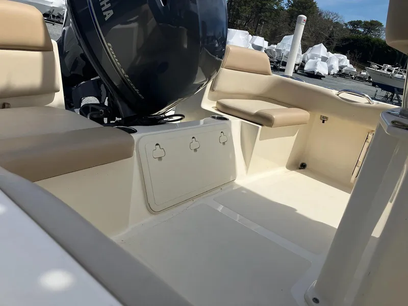 Slide: The Image of 2021 Scout 195 Sportfish boat interior with Yamaha engine, beige seating, and storage compartments. - 12