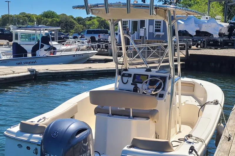 Slide: The Image of 2021 Scout 195 Sportfish boat docked, featuring a center console and Yamaha outboard motor. - 2