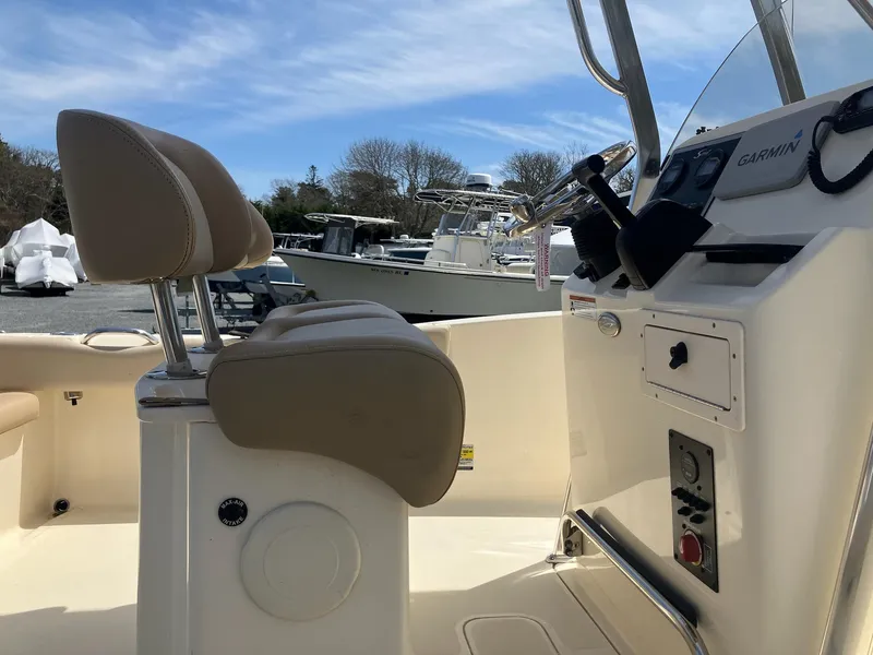 Slide: The Image of 2021 Scout 195 Sportfish boat interior with helm and seating, featuring Garmin equipment. - 7