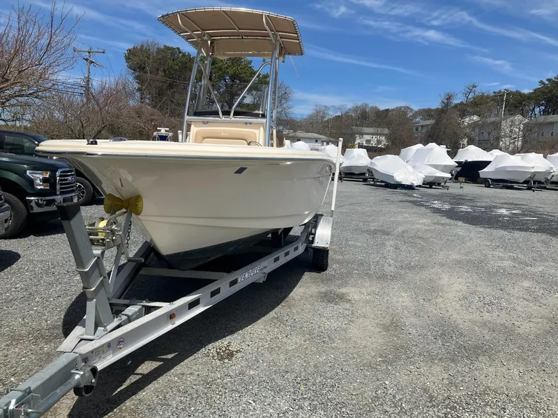 Slide: The Image of 2021 Scout 195 Sportfish boat on trailer in outdoor lot under blue sky. - 9