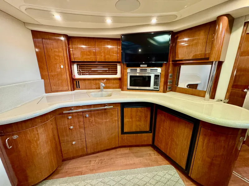 Slide: The Image of Luxurious 2004 Sea Ray 420 Sundancer yacht kitchen with wood cabinetry and modern appliances. - 18