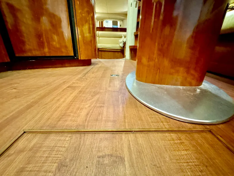 Slide: The Image of Interior of 2004 Sea Ray 420 Sundancer with polished wood flooring and seating area. - 23