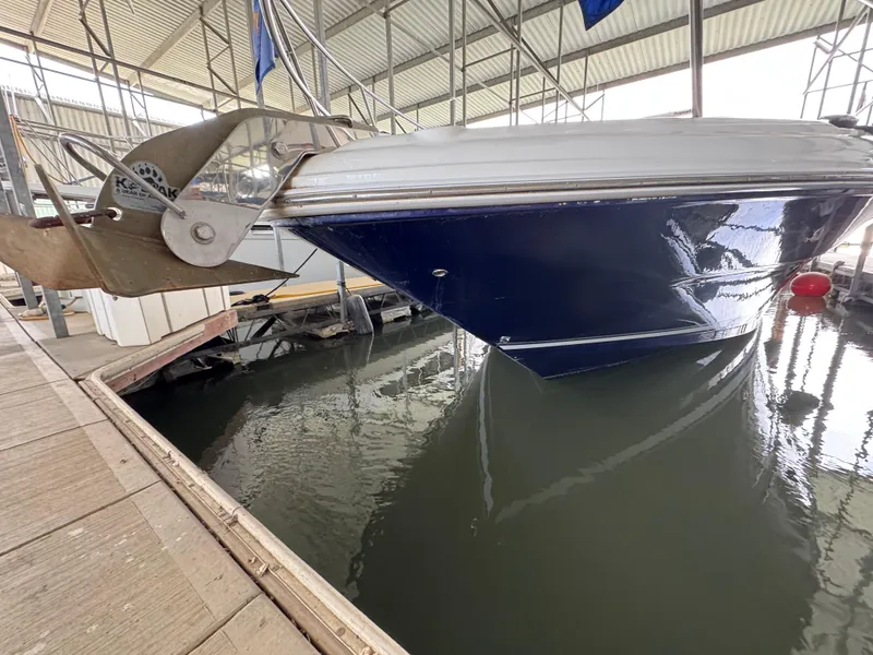 Slide: The Image of 2004 Sea Ray 420 Sundancer docked, showcasing sleek blue hull and anchor. - 5