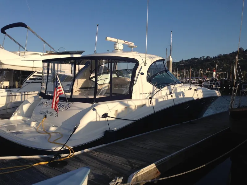Slide: The Image of 2004 Sea Ray 420 Sundancer yacht docked at marina, displaying American flag. - 6