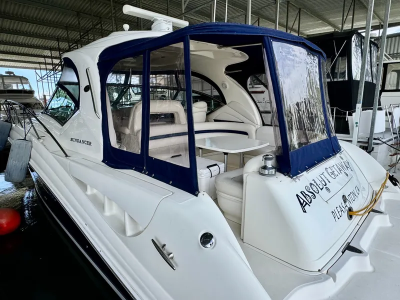 Slide: The Image of 2004 Sea Ray 420 Sundancer yacht docked in a marina, featuring a covered seating area. - 8