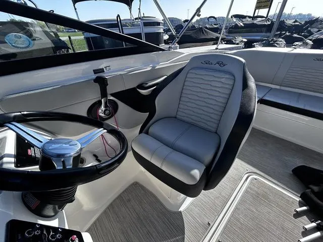 Slide: The Image of 2023 Sea Ray SPX 210 boat interior with steering wheel and cushioned seating. - 11