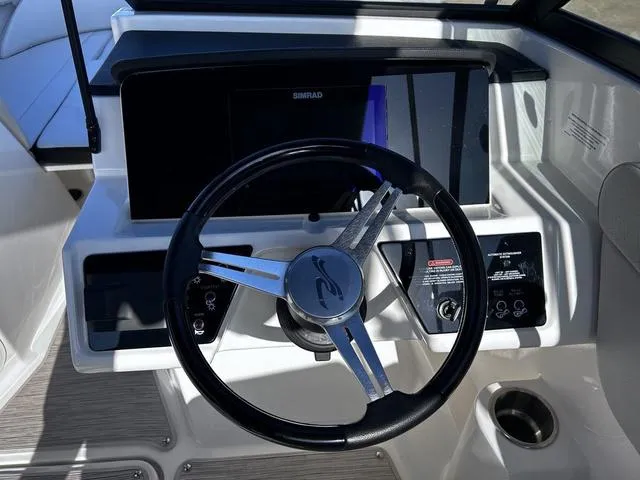 Slide: The Image of 2023 Sea Ray SPX 210 boat dashboard with steering wheel and control panel. - 12