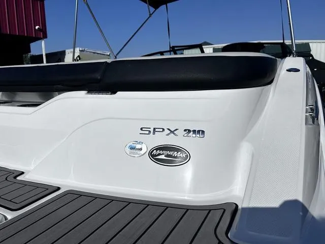 Slide: The Image of 2023 Sea Ray SPX 210 boat rear view with MarineMax logo, white and black design. - 5