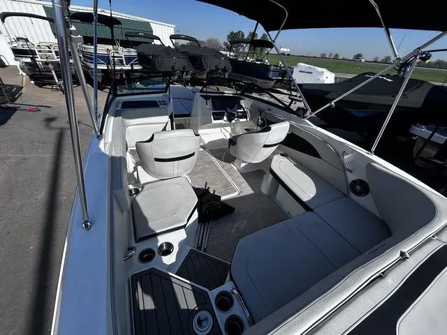 Slide: The Image of 2023 Sea Ray SPX 210 boat interior with seating and steering wheel, docked outdoors. - 7