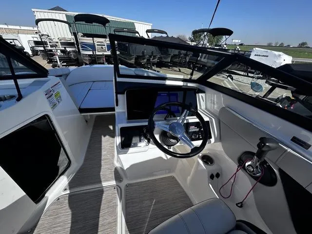Slide: The Image of 2023 Sea Ray SPX 210 boat interior with steering wheel and dashboard controls. - 8