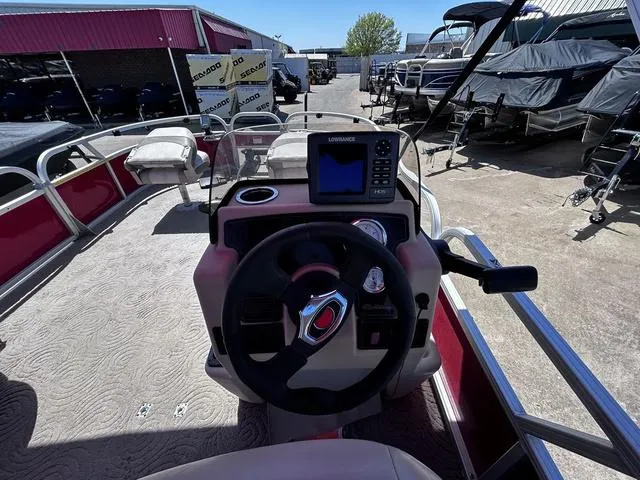 Slide: The Image of 2014 Sun Tracker Bass Buggy 18 DLX pontoon boat dashboard with steering wheel and navigation system. - 11