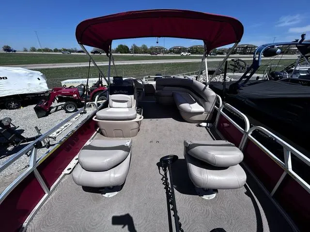 Slide: The Image of 2014 Sun Tracker Bass Buggy 18 DLX pontoon boat with seating and canopy, parked outdoors. - 7