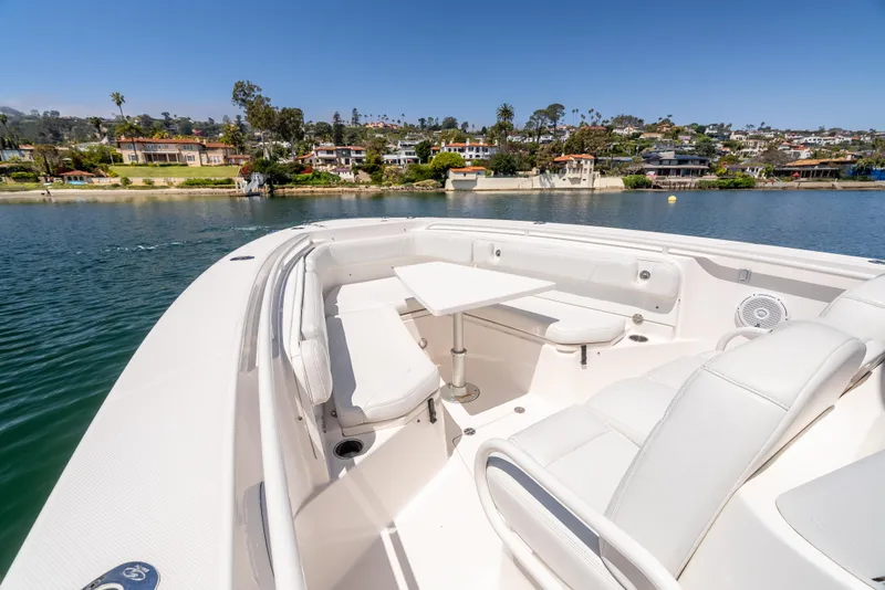 Slide: The Image of 2015 Everglades 325 Center Console boat with seating area, docked near waterfront homes. - 14