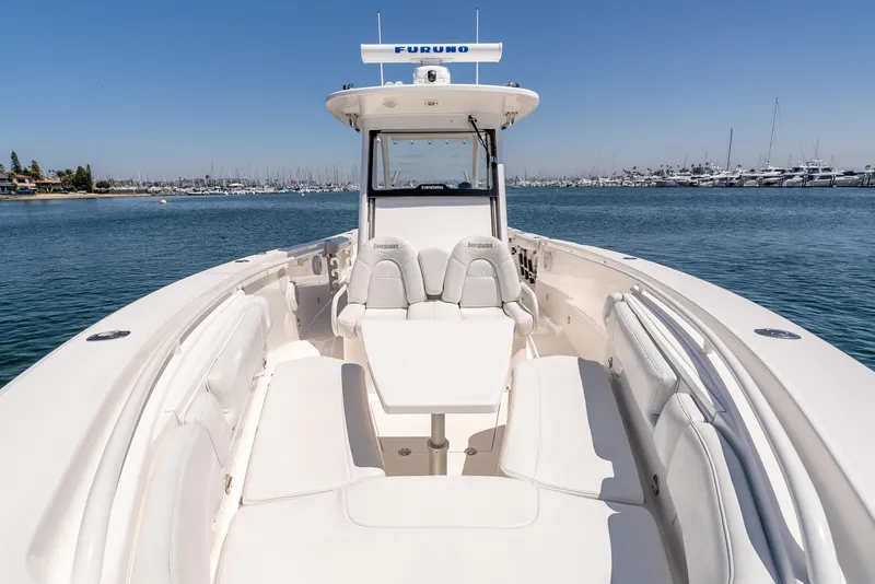 Slide: The Image of 2015 Everglades 325 Center Console boat on calm water, showcasing spacious seating and sleek design. - 16