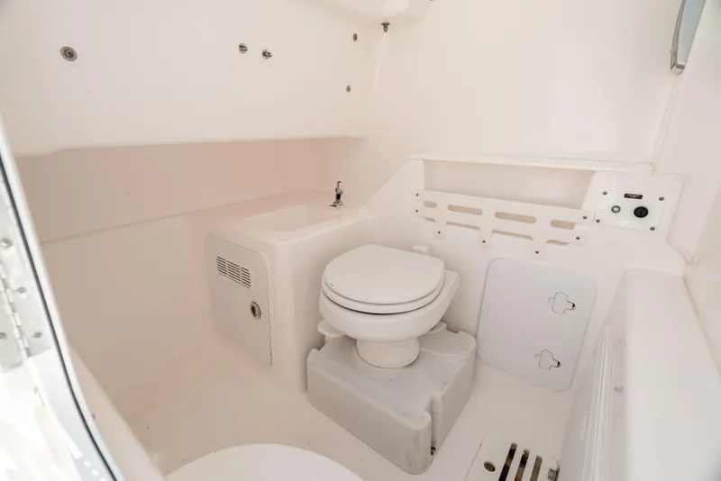 Slide: The Image of 2015 Everglades 325 Center Console boat interior with toilet and sink. - 18
