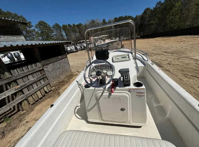 Slide: The Image of 2017 Carolina Skiff 18 JVX CC boat interior with steering console, parked outdoors. - 7
